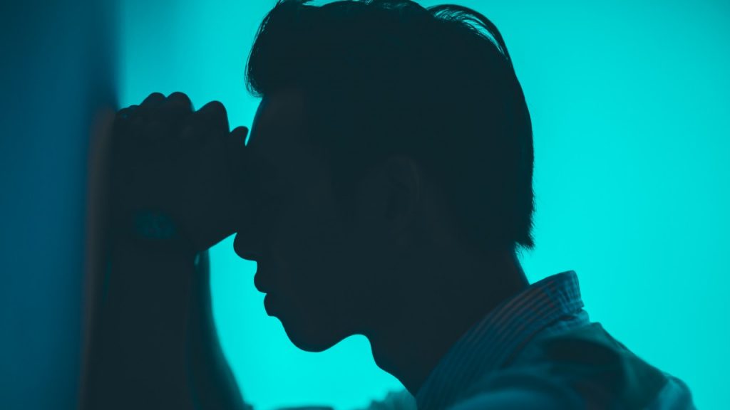 man praying against wall