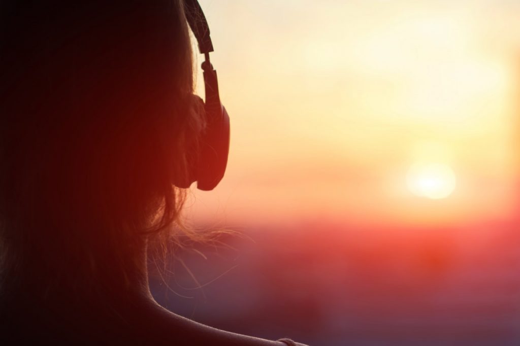 Person wearing headphones watching sunset