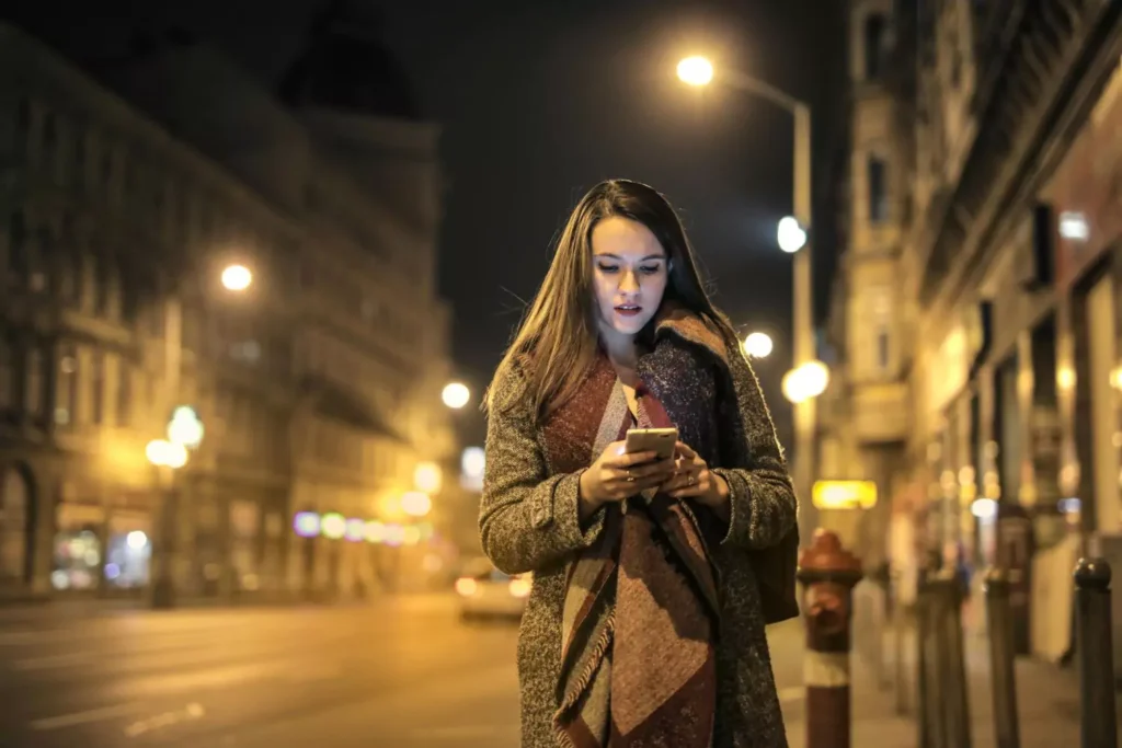 a woman looking at her phone at night
