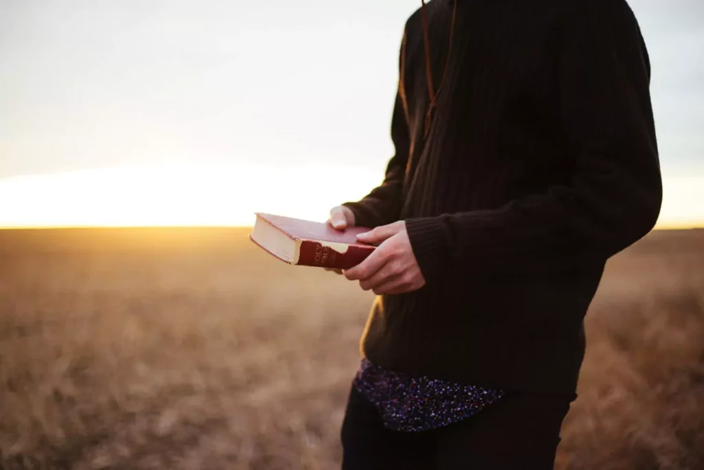 a man holding a Bible thinking, do I really know Him (Jesus)?