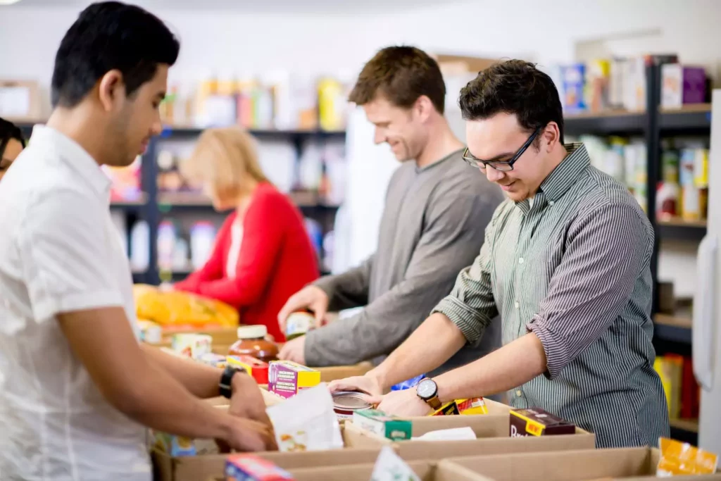 Several young men serving their community by packing boxes of food