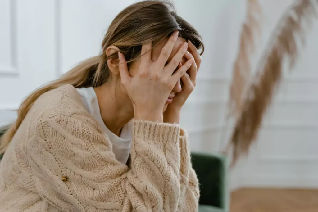 Woman with her head in her hands, frustrated from a change of plans