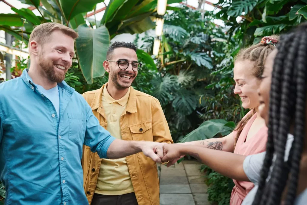 4 people fist bumping, an introvert community