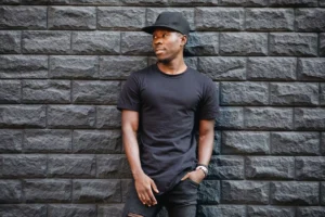 an introverted man standing by a wall