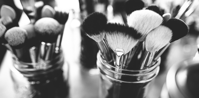 Several makeup brushes sitting in jars