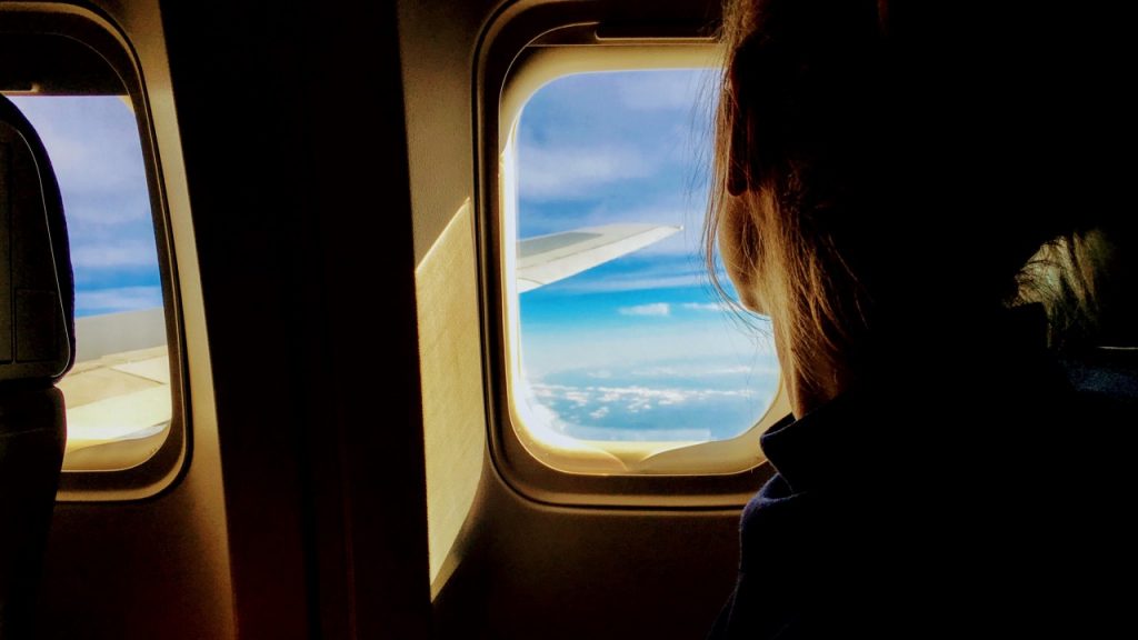 woman looking out plane window