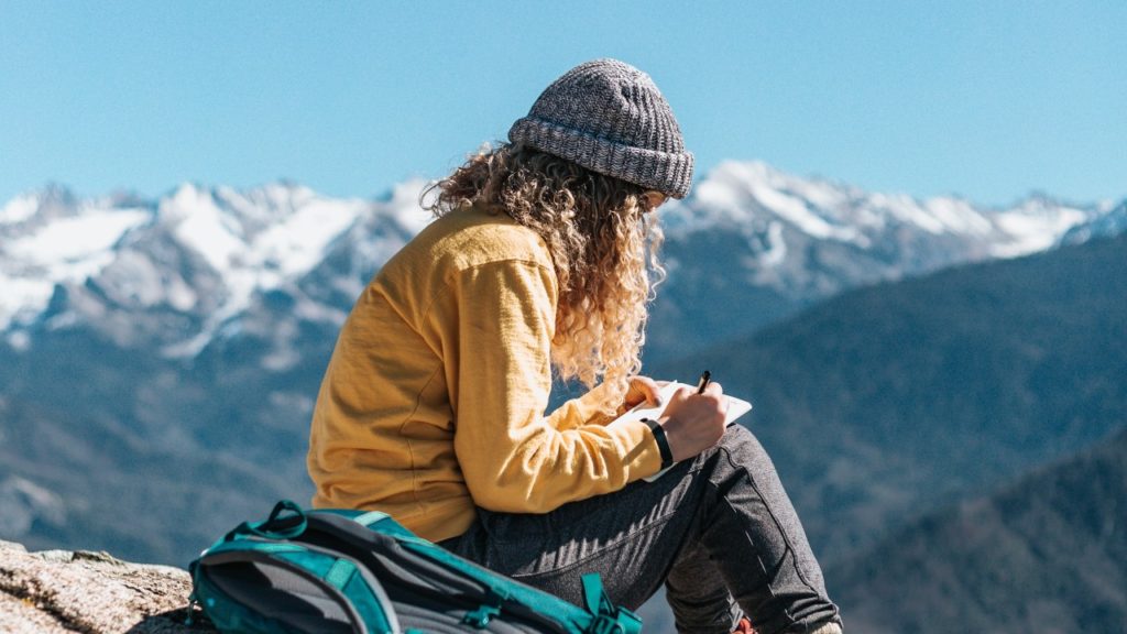 woman on mountain writing