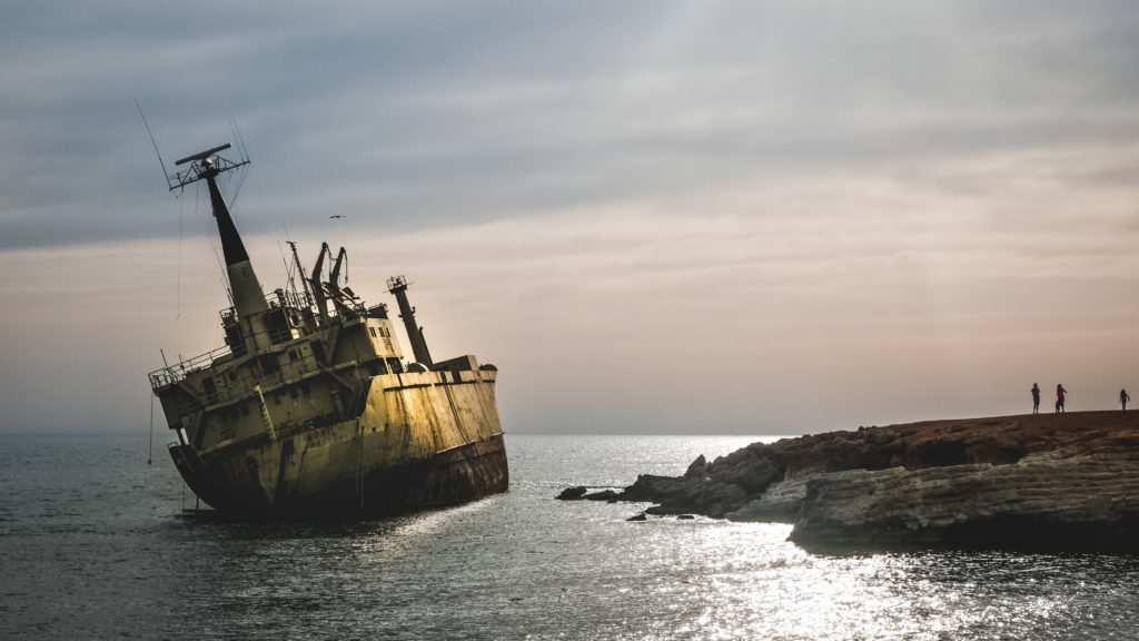 ship leaning at sea at sunset