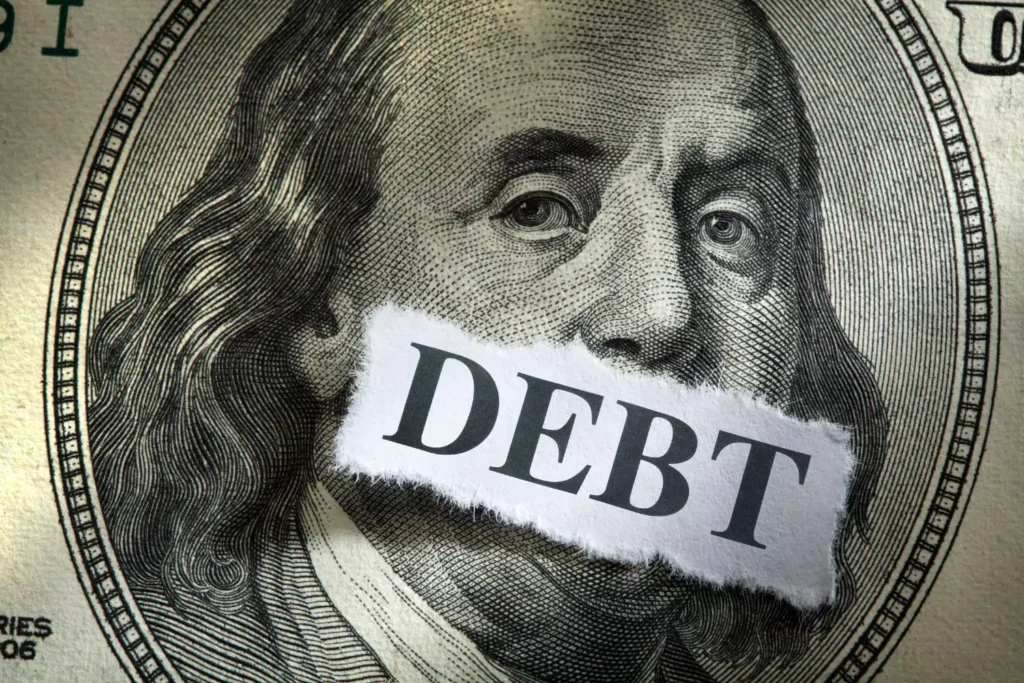 a photo of George Washington on the 100 dollar bill with tape over his mouth that says debt