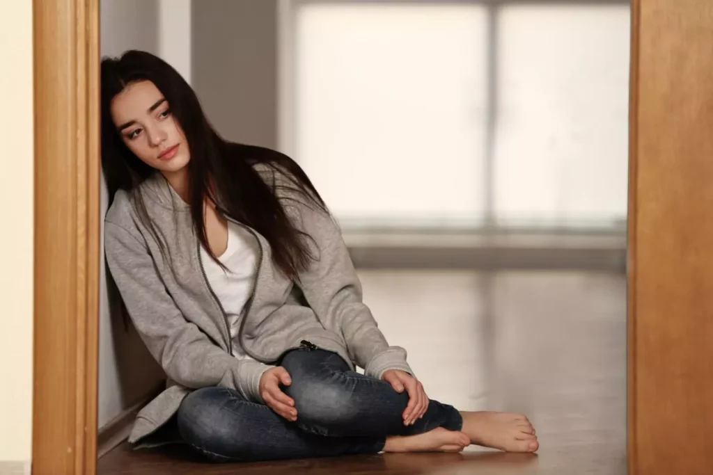 a woman in despair sitting on the ground