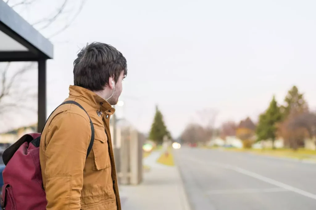 a man waiting at a bus stop, symbolizing waiting for a spouse