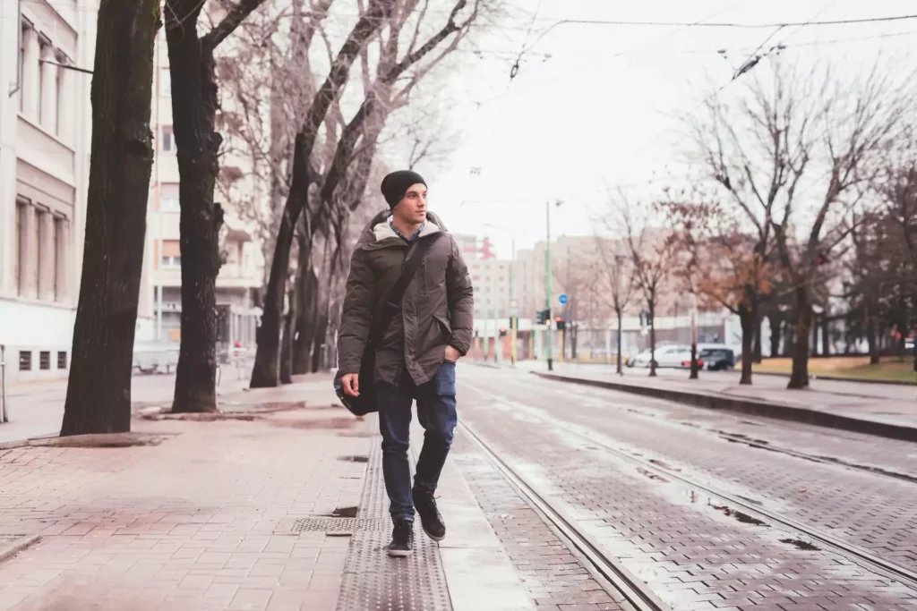 young guy walking in a city thinking about change