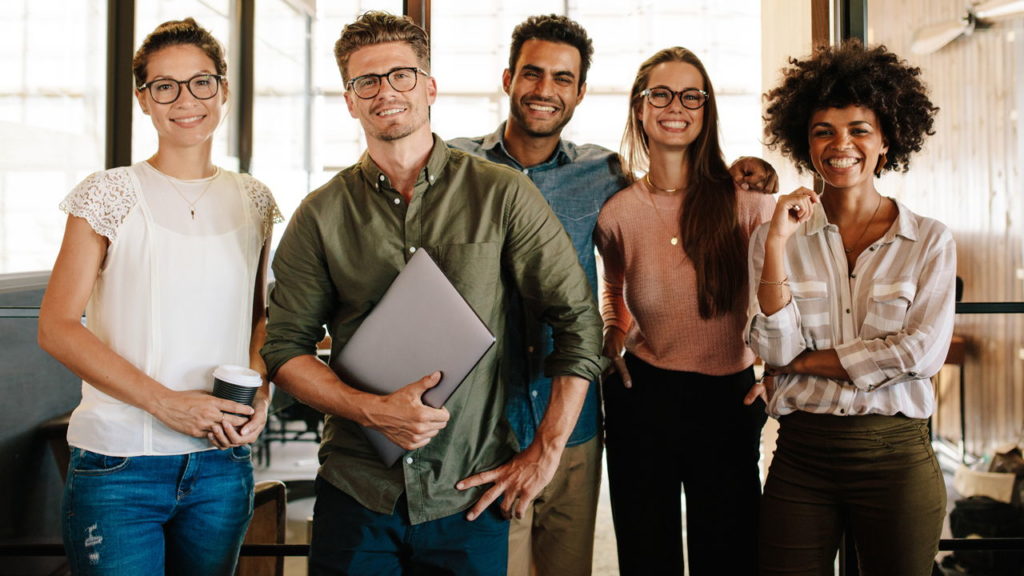 group of millennials in an office smiling